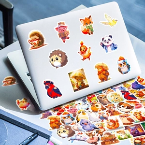 Detailed view of cute cartoon animal stickers applied to a silver laptop lid and desk