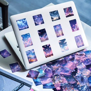 Close-up of dreamy starry sky aesthetic stickers on a white laptop cover surface