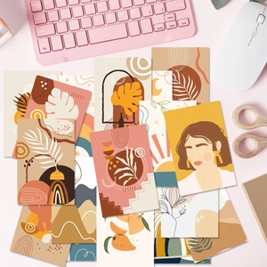 Flat lay of artistic Boho wall decor cards with abstract illustrations on a desk