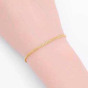 Detailed view of a classic gold-toned S925 sterling silver Cuban link bracelet on wrist