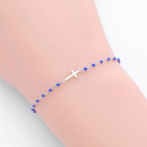 Détail macro du bracelet en argent S925 avec perles en émail bleu et breloque en croix