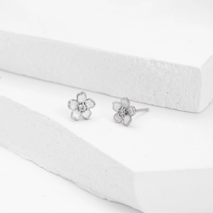 Vue détaillée des puces d'oreilles fleur de cerisier en argent s925 et émail blanc