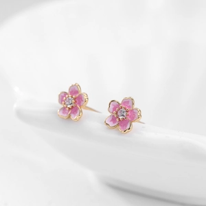 Détail macro de clous d'oreilles fleur de cerisier en argent s925 et émail rose
