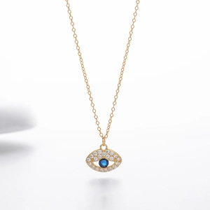 Detalle del colgante de ojo turco dorado con gema azul y pavé de circonitas blancas