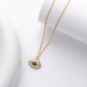 Detalle de colgante ojo turco de plata s925 con gema azul y circón en cadena de oro