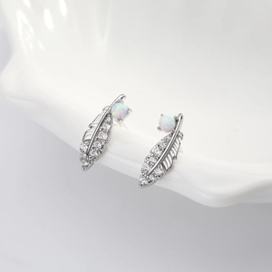 Detailed shot of 925 silver feather earrings with micro-set zircons and white opal