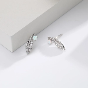 Detail of 925 silver feather earrings with opal and sparkling cubic zirconia stones