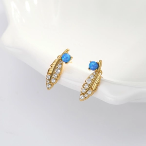 Detailed close-up of golden feather earrings with white diamonds and blue opal stones