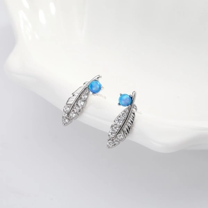 925 sterling silver feather earrings with white zircon and blue opal stone on ceramic tray