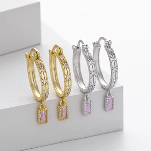 Makroaufnahme von quadratischen Creolen in Silber und Gold mit rosa Kristalldetails