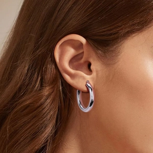 Gros plan de boucles d'oreilles créoles épaisses en argent S925 sur un mannequin