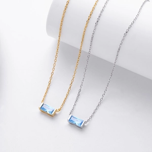 Close-up of gold and silver S925 necklaces with rectangular blue zircon pendants