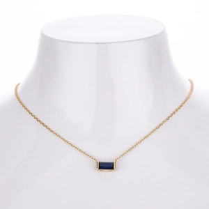 Detail of s925 silver necklace featuring a rectangular blue zircon pendant on golden chain