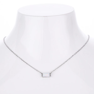 Macro shot of rectangular opal pendant necklace on a white neck bust display stand