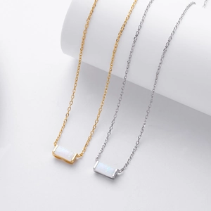 Detailed shot of rectangular rainbow opal pendants in gold and silver chain settings