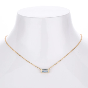 Detail of s925 silver necklace with rectangular light blue zircon on a white neck bust