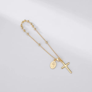 Vue détaillée d'un bracelet chapelet doré avec croix et médaille de la Vierge Marie