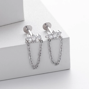 Vue macro d'un clou d'oreille en argent S925 avec zircons marquise et fine chaîne