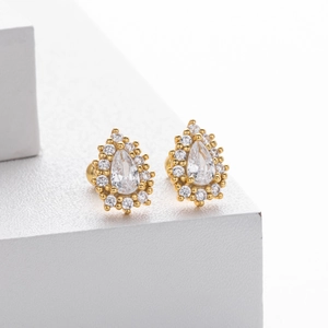 Gros plan de boucles d'oreilles dorées avec oxydes de zirconium taille poire et halo