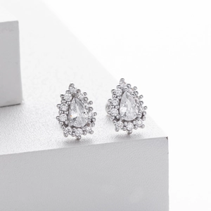 Détail macro de boucles d'oreilles en argent poire avec halo de zircons brillants