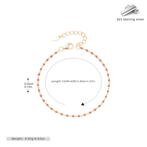 Detail of 925 sterling silver gold plated bracelet with red enamel beads and lobster clasp