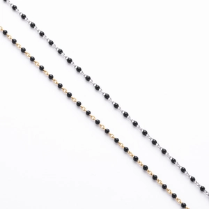 Detailed close-up of gold and silver beaded chains with minimalist black round beads
