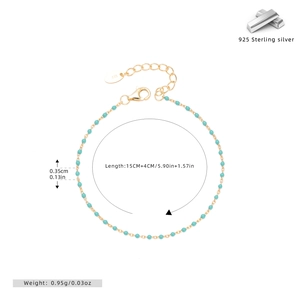 Macro detail of S925 silver gold-plated bracelet with blue-green beads and lobster clasp