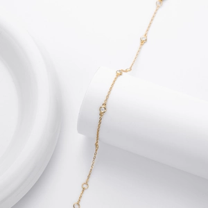 Elegant gold S925 sterling silver chain bracelet with round inlaid gemstones on white stand