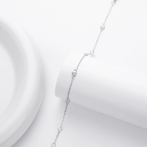 Macro detail of minimalist S925 sterling silver chain with bezel-set round zircons