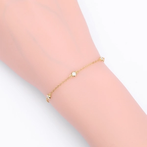 Detail of a gold S925 sterling silver thin bracelet with three bezel-set round crystals