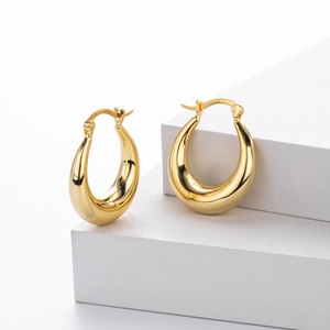 Boucles d'oreilles créoles goutte en argent S925 doré sur supports géométriques blancs