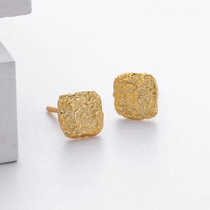 Detail van de vierkante gouden S925 zilveren oorbellen met lava-textuur