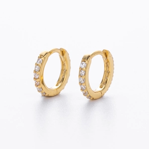 Detailed close-up of golden S925 silver huggie hoop earrings with sparkling zircon stones