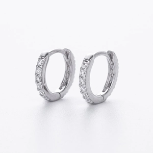 Close-up of S925 sterling silver huggie earrings with sparkling cubic zirconia inlay