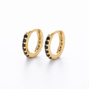 Macro detail of gold huggie earrings with double rows of pavé-set black zircons