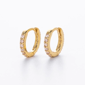 Macro shot of gold-plated hoop earrings with sparkling cubic zirconia on a white background