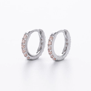 Close-up of S925 silver huggie earrings with pink pavé-set cubic zirconia stones