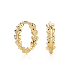 Detail van gouden huggie hoop oorbellen met lauwerkrans ontwerp op witte achtergrond