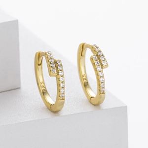 Detail of gold S925 silver lightning bolt earrings with pavé cubic zirconia
