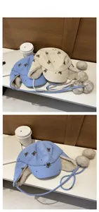 Dettaglio del cappello da aviatore in velluto con stampa orso, paraorecchie e pompon soffici