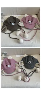 Close-up of cute bear ear plush hats with fluffy pom-poms and warm faux fur lining