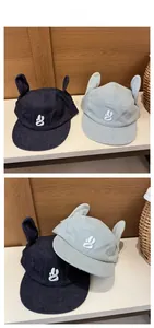 Vue détaillée de casquettes en denim avec oreilles 3D et logo blanc brodé