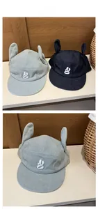 Détail de casquettes en denim avec oreilles de lapin mignonnes et logo G brodé blanc