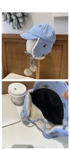 Dettaglio del cappello da aviatore in velluto azzurro con stampa orso e fodera in pile