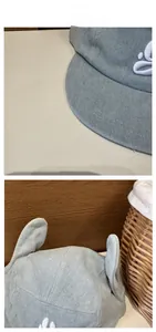 Détail d'une casquette en jean bleu clair avec oreilles de lapin 3D et broderie blanche
