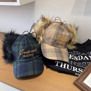 Retro plaid trapper hats with faux fur earflaps and West Coast embroidery on wood background