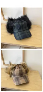 Detail of plaid baseball cap with plush earflaps and adjustable top tie for winter