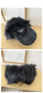 Detail of winter trapper hat with black faux fur texture and green plaid pattern brim