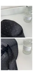 Detail view of black linen sun hat with white micro polka dots and a wide brim