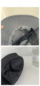 Close-up of black breathable wide brim sun hat with white polka dots and windproof strap